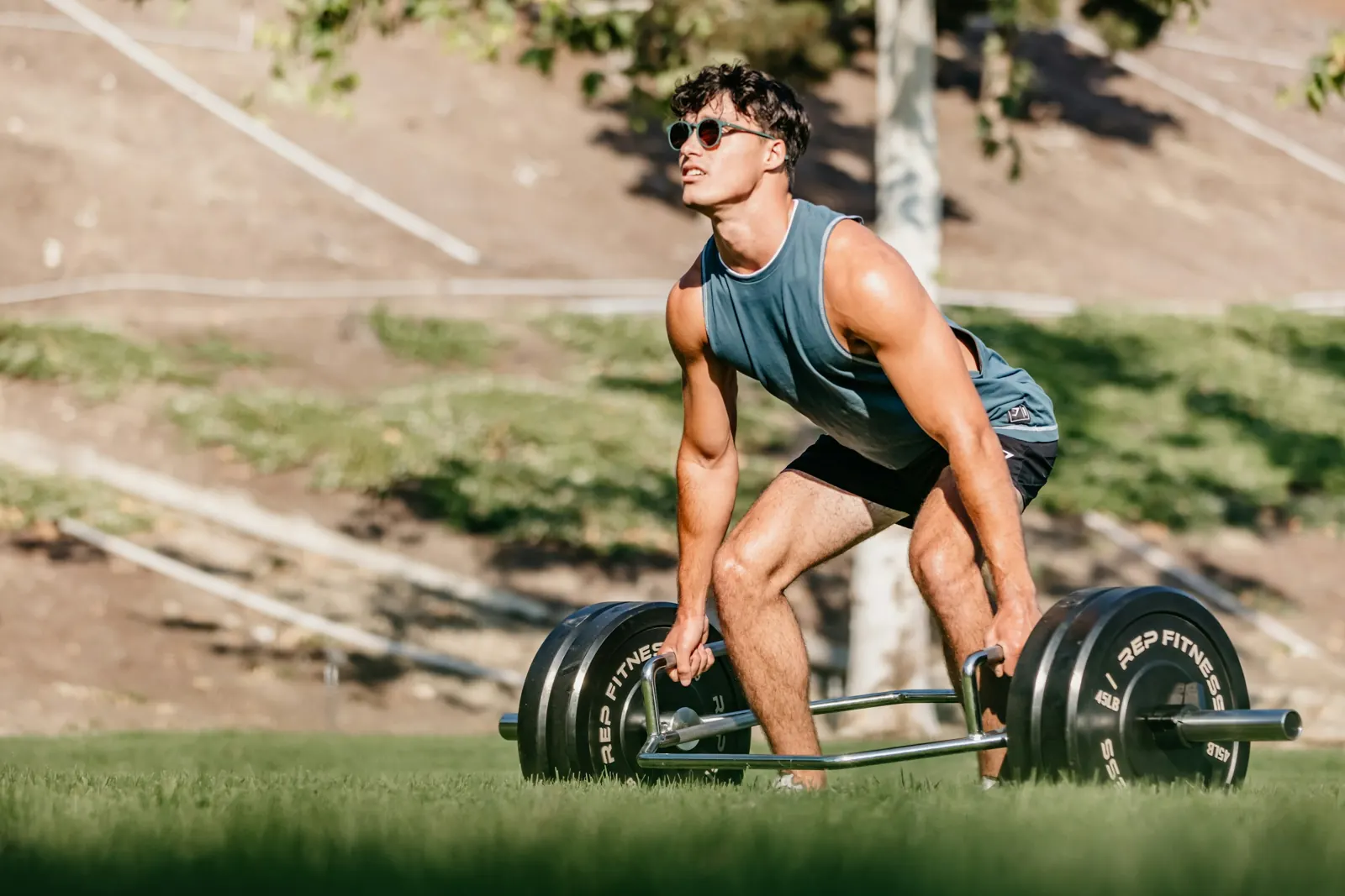 Athlete deadlifting a loaded barbell outdoors
